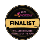 Round award badge, gold text and accents on black background with hot pink & purple logo. Finalist, Wellness Services Business Of The Year -Ausmumpreneur Awards 2023.