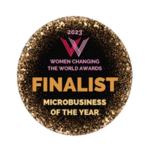 Round award badge, gold text and accents on black background with hot pink logo. Finalist Microbusiness of the Year - Women Changing the World Awards 2023